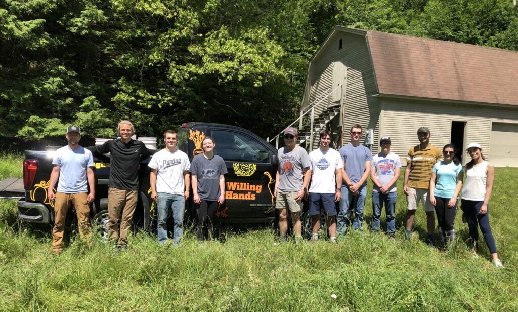 A row of volunteers from Hypertherm standing in front of the Willing Hands truck