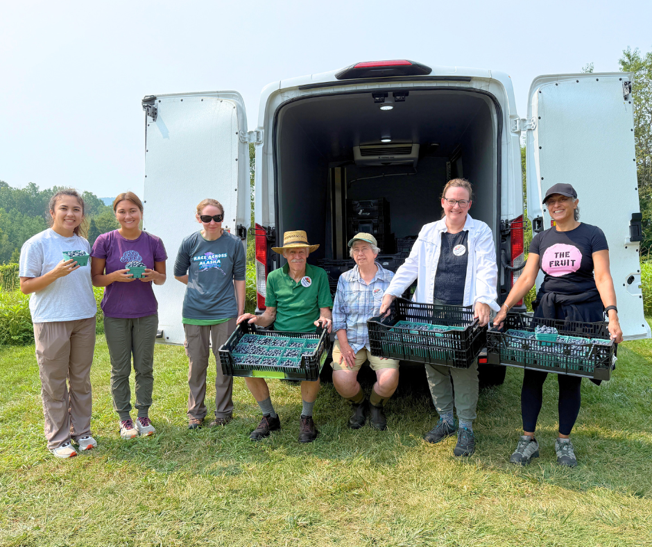 Volunteers pose with gleaned blueberries at Wild Hill Organics.